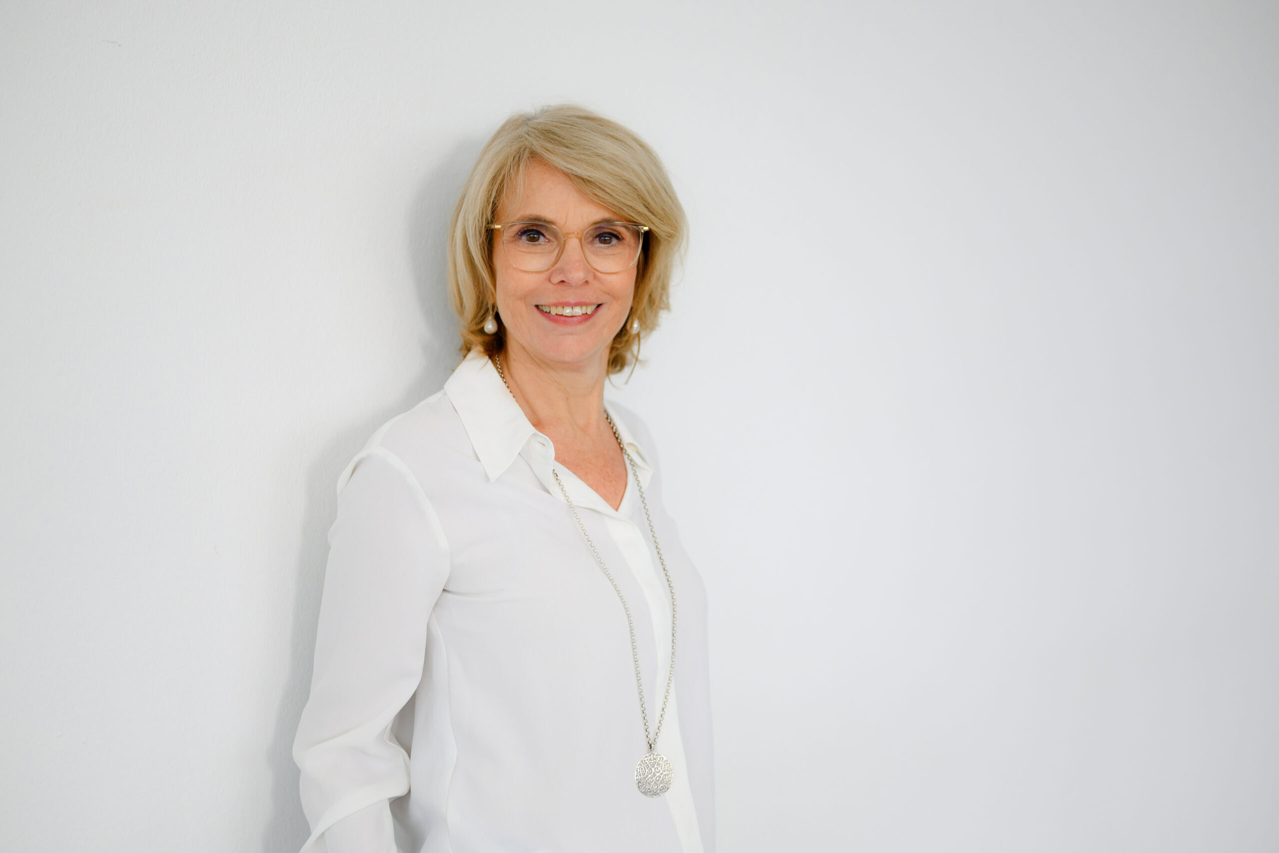 Verena Schiffer Personalberatung stehend an der Wand freundlich lächelnd